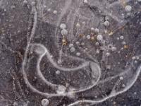 Viele kleinere runde Lufteinschlüsse und ovale Struktur im Eis